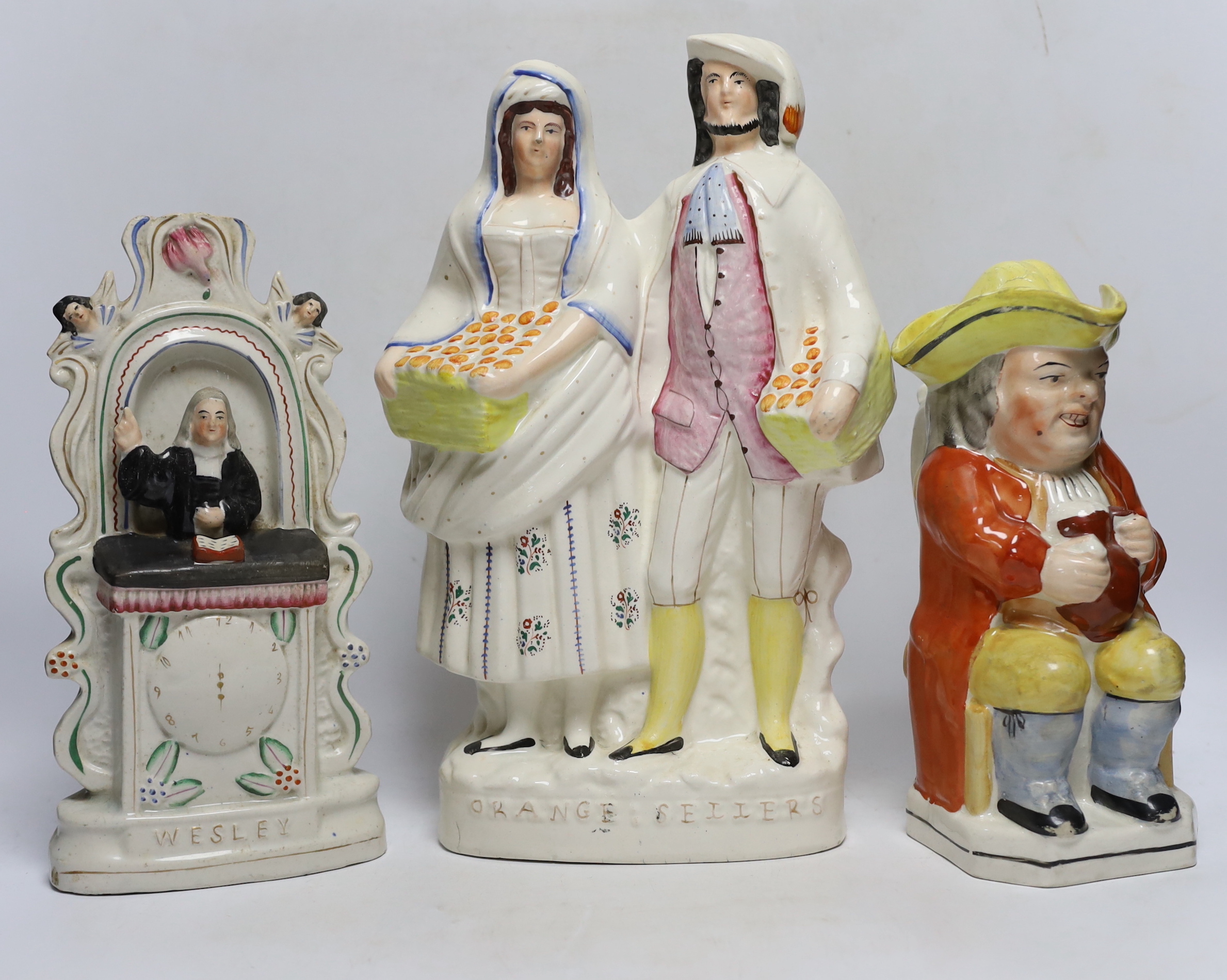 Seven 19th century Staffordshire figure groups including Orange Sellers and Wesley, together with a Toby jug, 35cm high